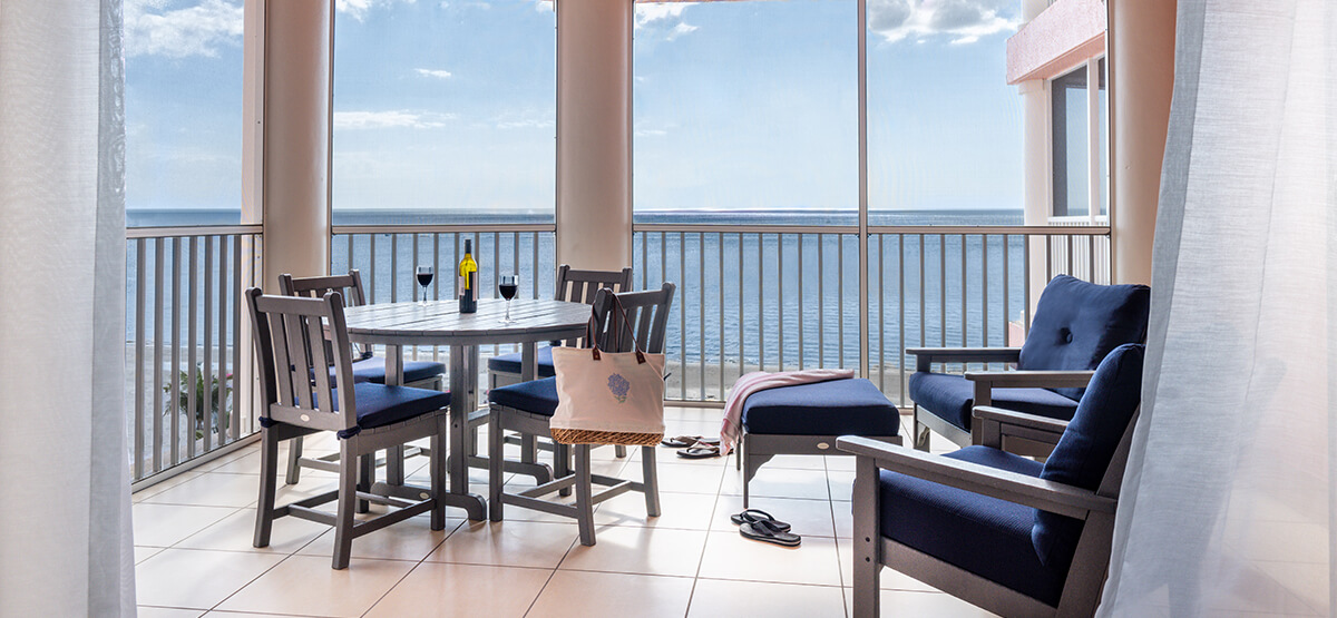 Beachfront Villa Patio with large windows and a bistro table.